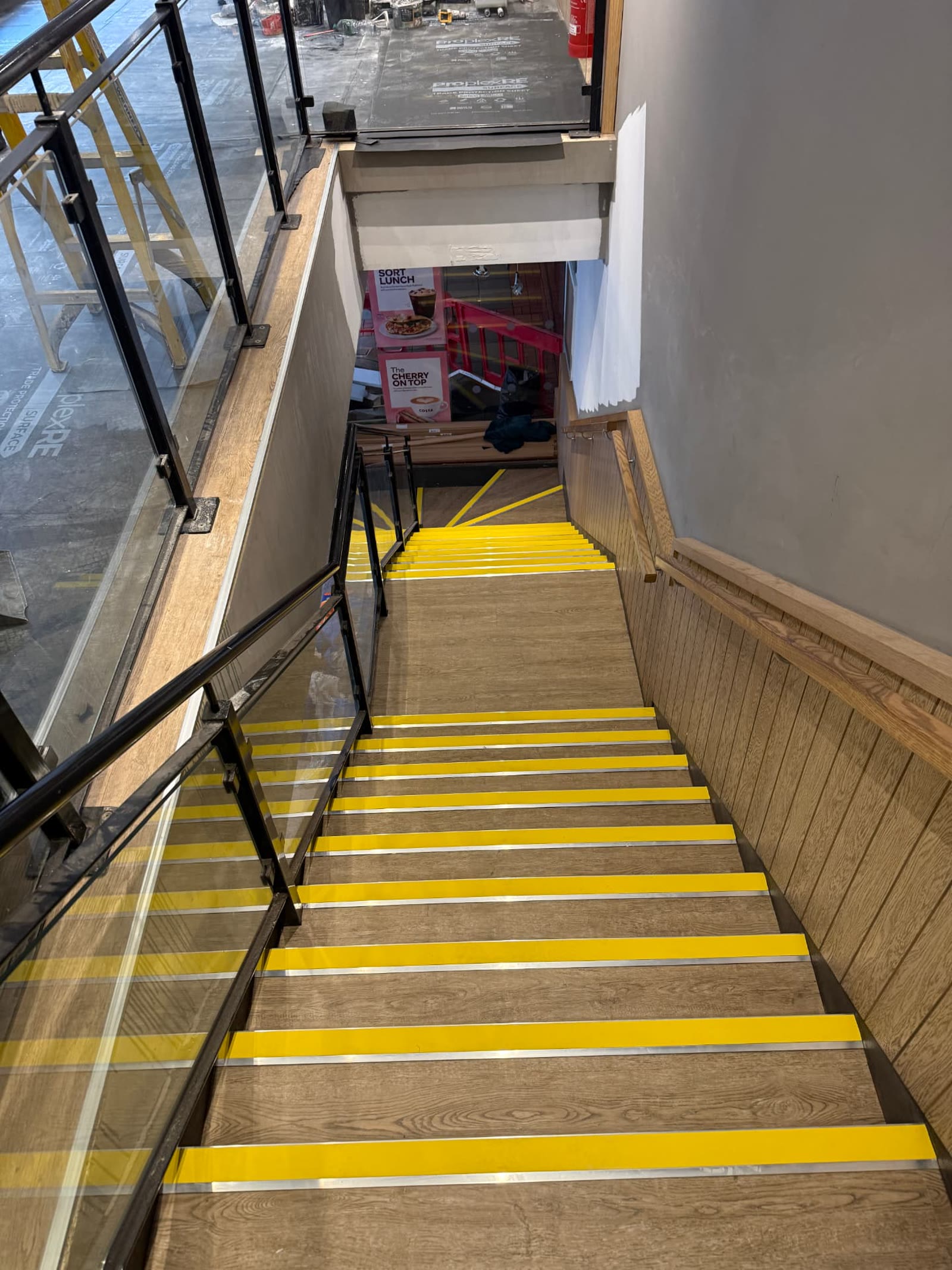 Wood-effect commercial stairs with yellow safety nosings