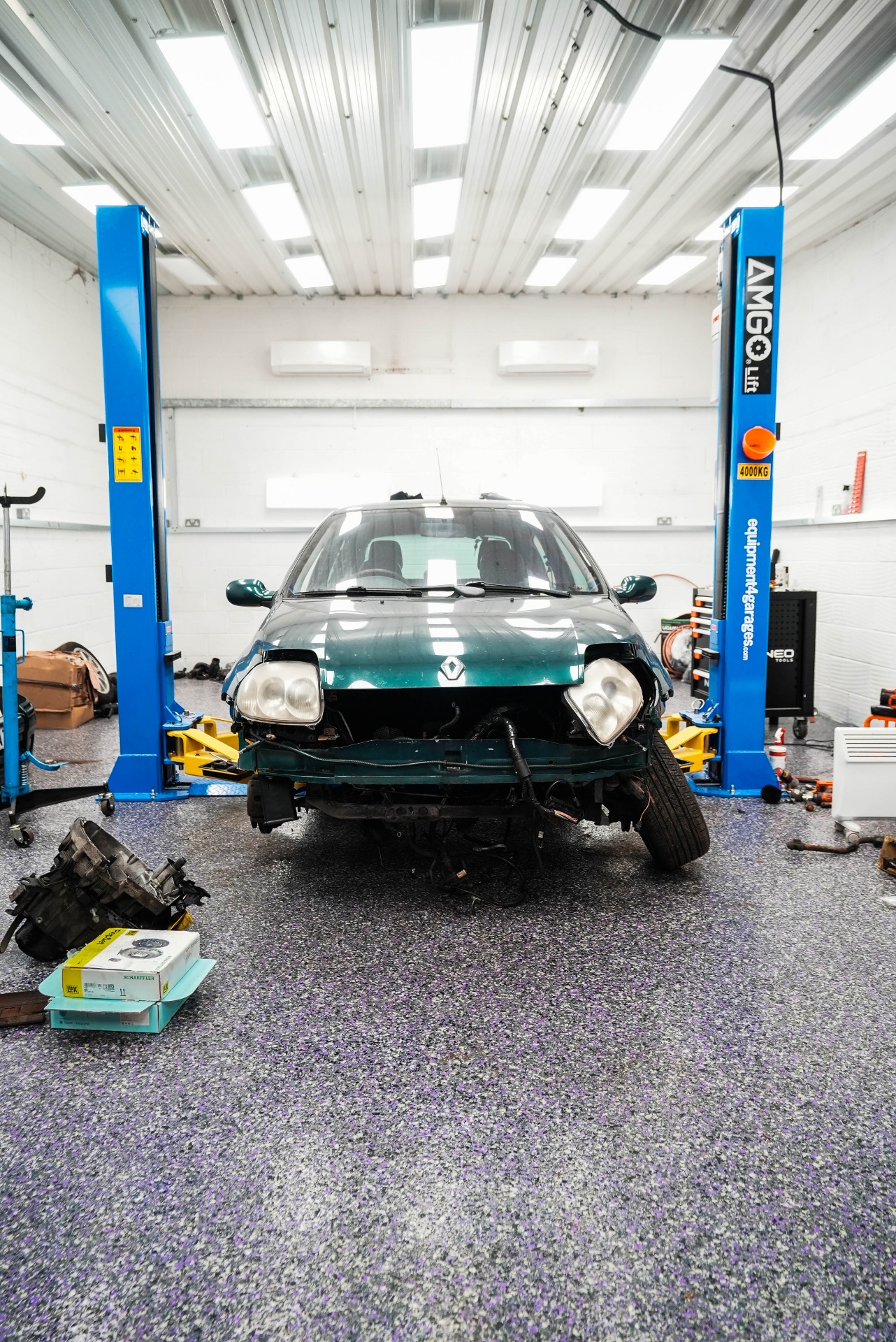 flake resin garage floor front view with vehicle on hydraulic lift — premium garage flooring