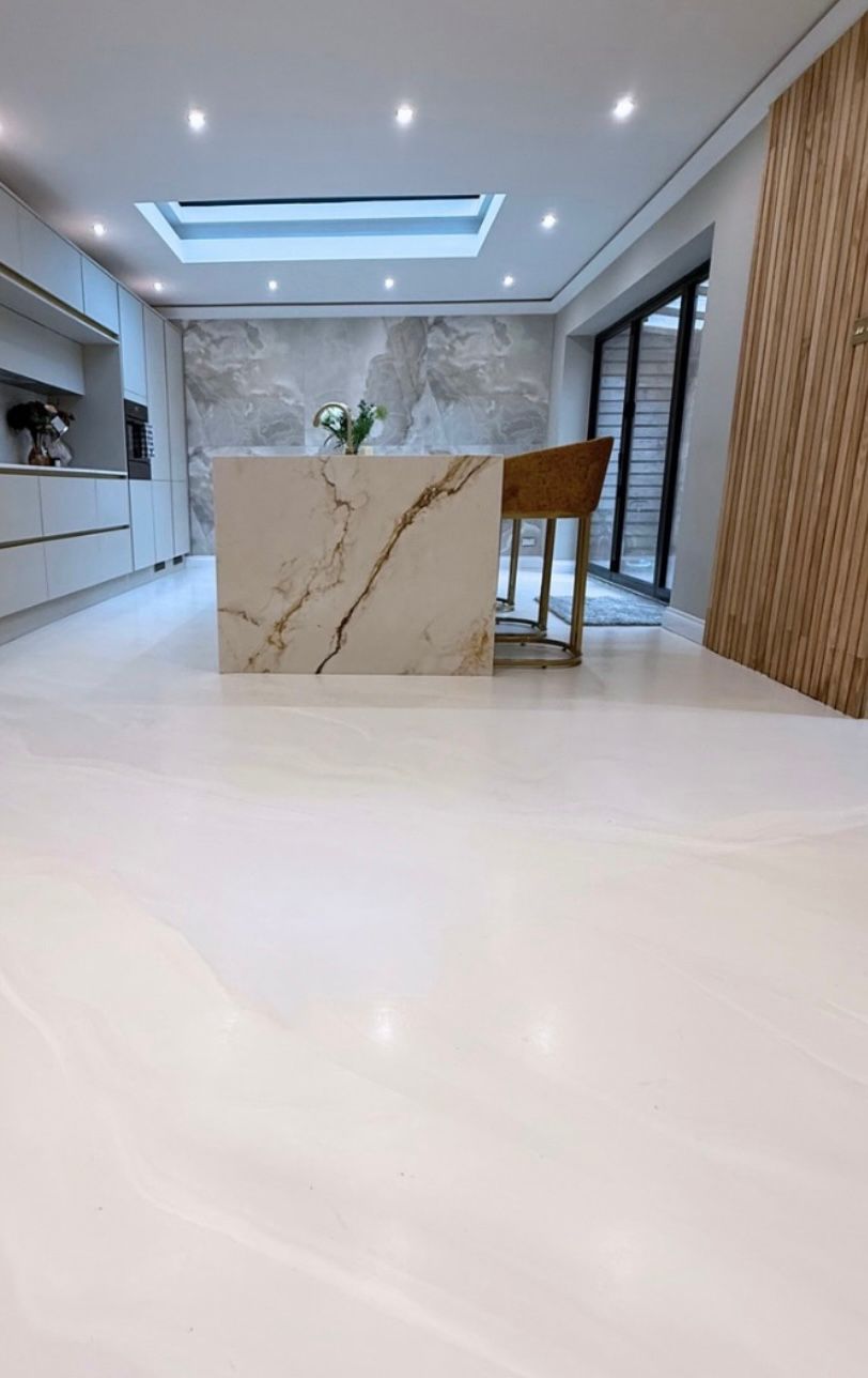 seamless soft pearl PU comfort resin floor in luxury kitchen with calacatta marble island and skylight