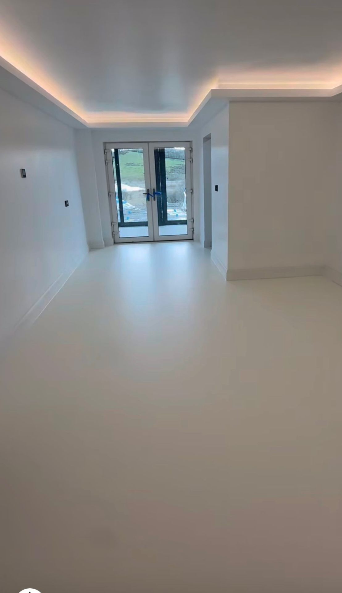 warm pearl PU comfort resin floor in a snug with cove-lit ceiling and french doors